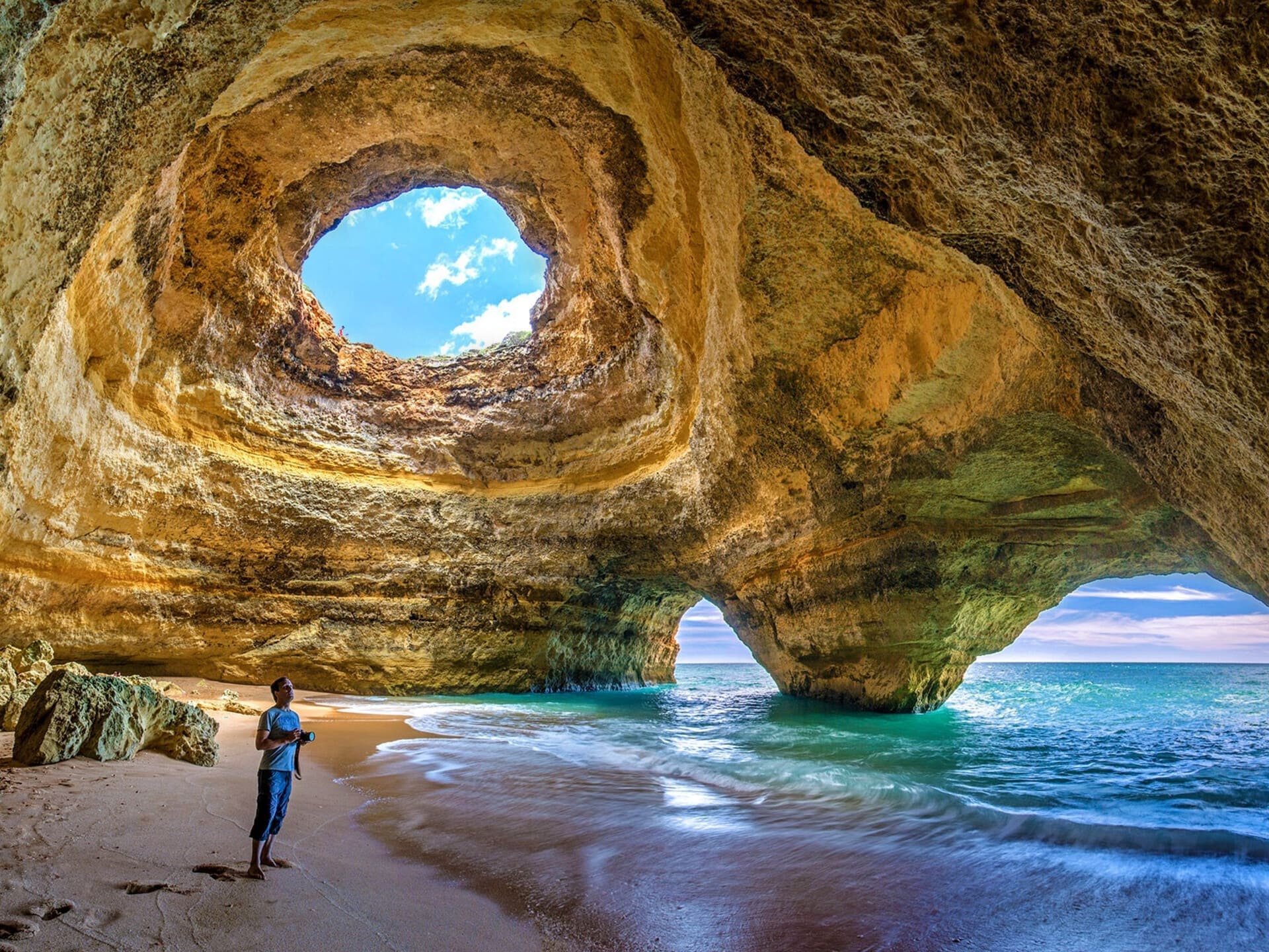 Gruta de Benagil com luz natural sobre a praia.